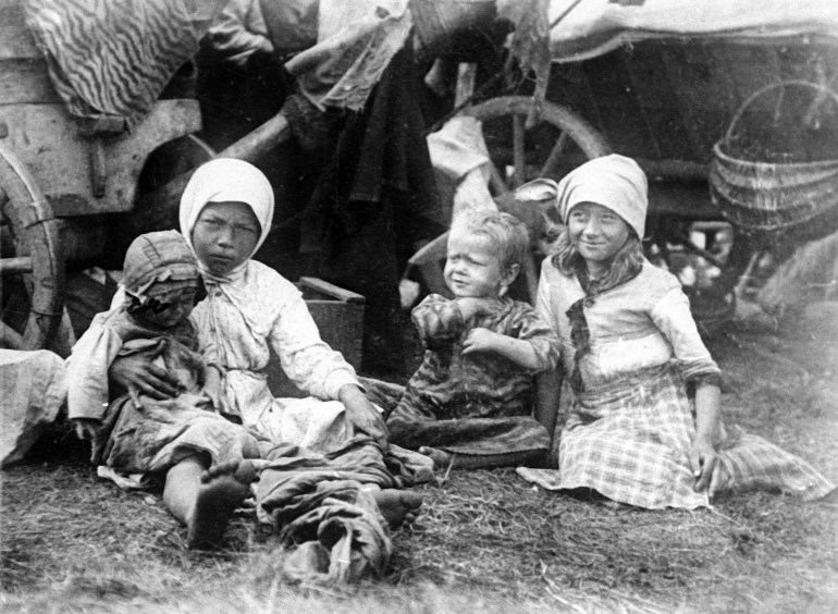 Small children, victims of the Russian famine, are seen seated on the ground, 1921. (AP Photo)