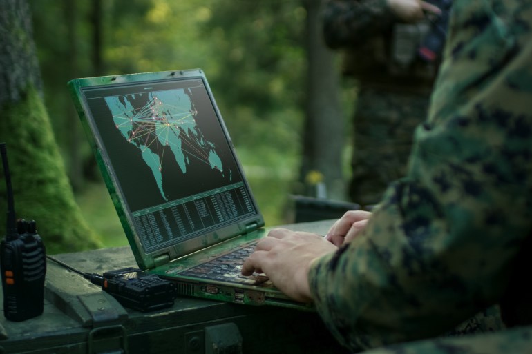 Military Operation in Action, Soldiers Using Military Grade Laptop Targeting Enemy with Satellite. In the Background Camouflaged Tent on the Forest.; Shutterstock ID 761940757; purchase_order: aljazeera ; job: ; client: ; other: