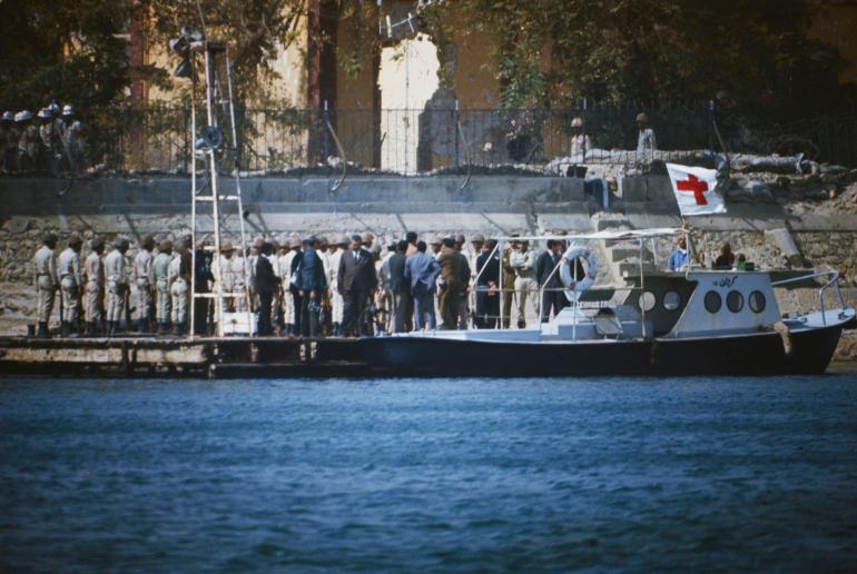 An Egyptian Army honour guard presents arms as two coffins are carried ashore on the Egyptian side of the Suez Canal at El Qantara, Egypt, 23rd February 1973. The coffins carry victims of downed Libyan Arab Airlines Flight 114 (LN 114), from Tripoli to Cairo via Benghazi, shot down by two Israeli F-4 Phantom II fighter jets, killing 108 of the 113 people on board. (Photo by Bettmann Archive/Getty Images)