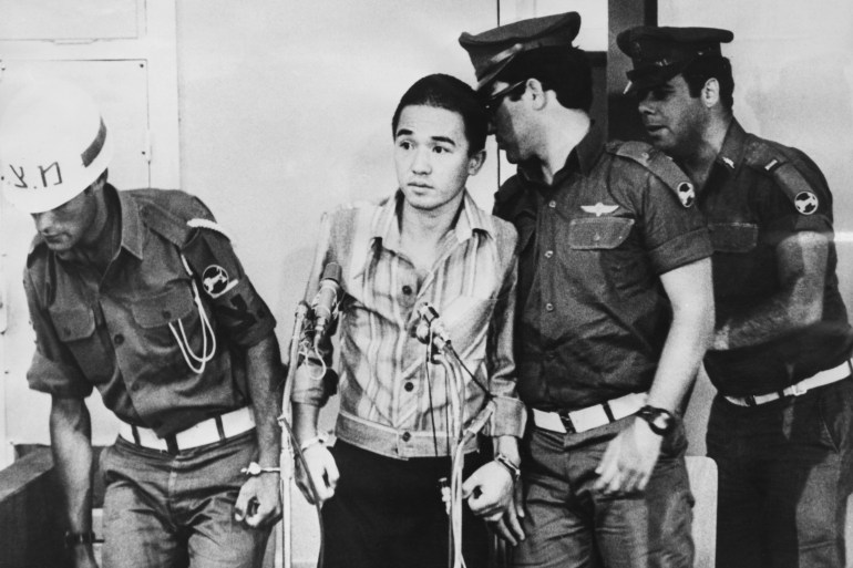 Israeli military police guard Japanese terrorist Kozo Okamoto (centre) of the far-left terrorist group the Japanese Red Army, at the start of his trial at Zrifin army camp, Israel, 12th July 1972. Okamoto is the only survivor of the three Red Army members who took part in the Lod Airport Massacre, killing 25 people. (Photo by Keystone/Hulton Archive/Getty Images)