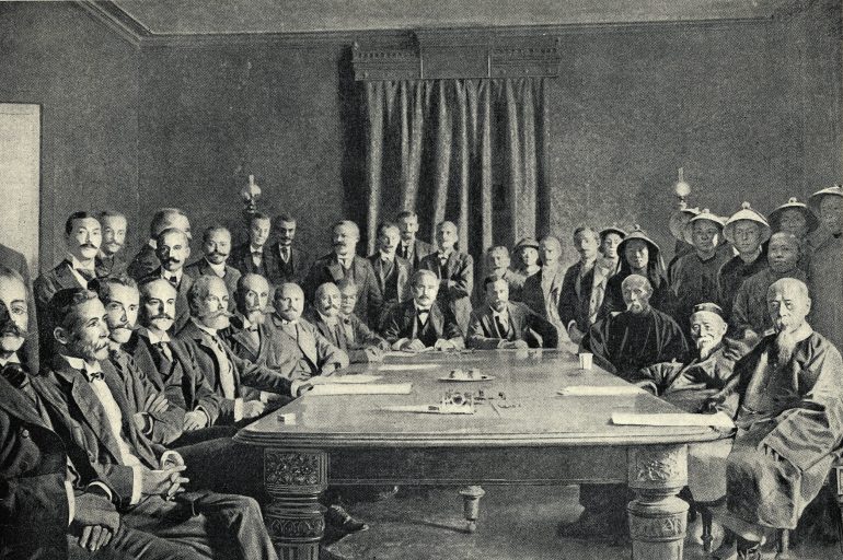 (Original Caption) Illustration showing the signing of the Peace Protocol of Peking by the Plentipotentaries, bringing an end to the Boxer Rebellion in China. On the left side of the table is the multi-national delegation from the east and on the right are the Chinese leaders. Undated illustration circa 1900.