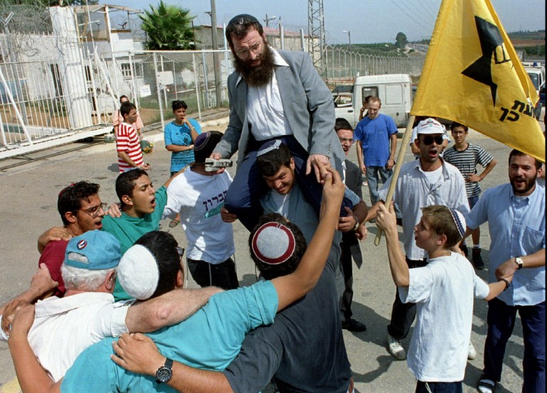 Leader of the anti-Arab Kach movement Baruch Marzel on shoulders by supporters, vows to work against Prime Minister
